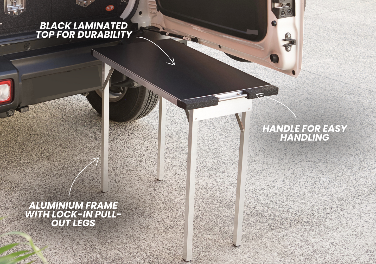 Suzuki Jimny XL pull-out table attached to vehicle rear with black laminated top and aluminum frame legs