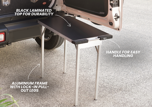 Suzuki Jimny XL pull-out table attached to vehicle rear with black laminated top and aluminum frame legs